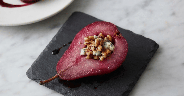 Poached pear plated with a glossy syrup drizzle